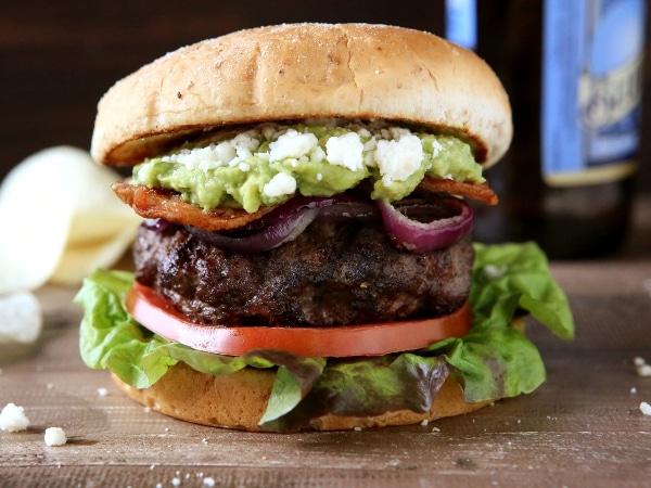 Bacon Guacamole Burgers with Grilled Onions and Cotija Cheese | completelydelicious.com