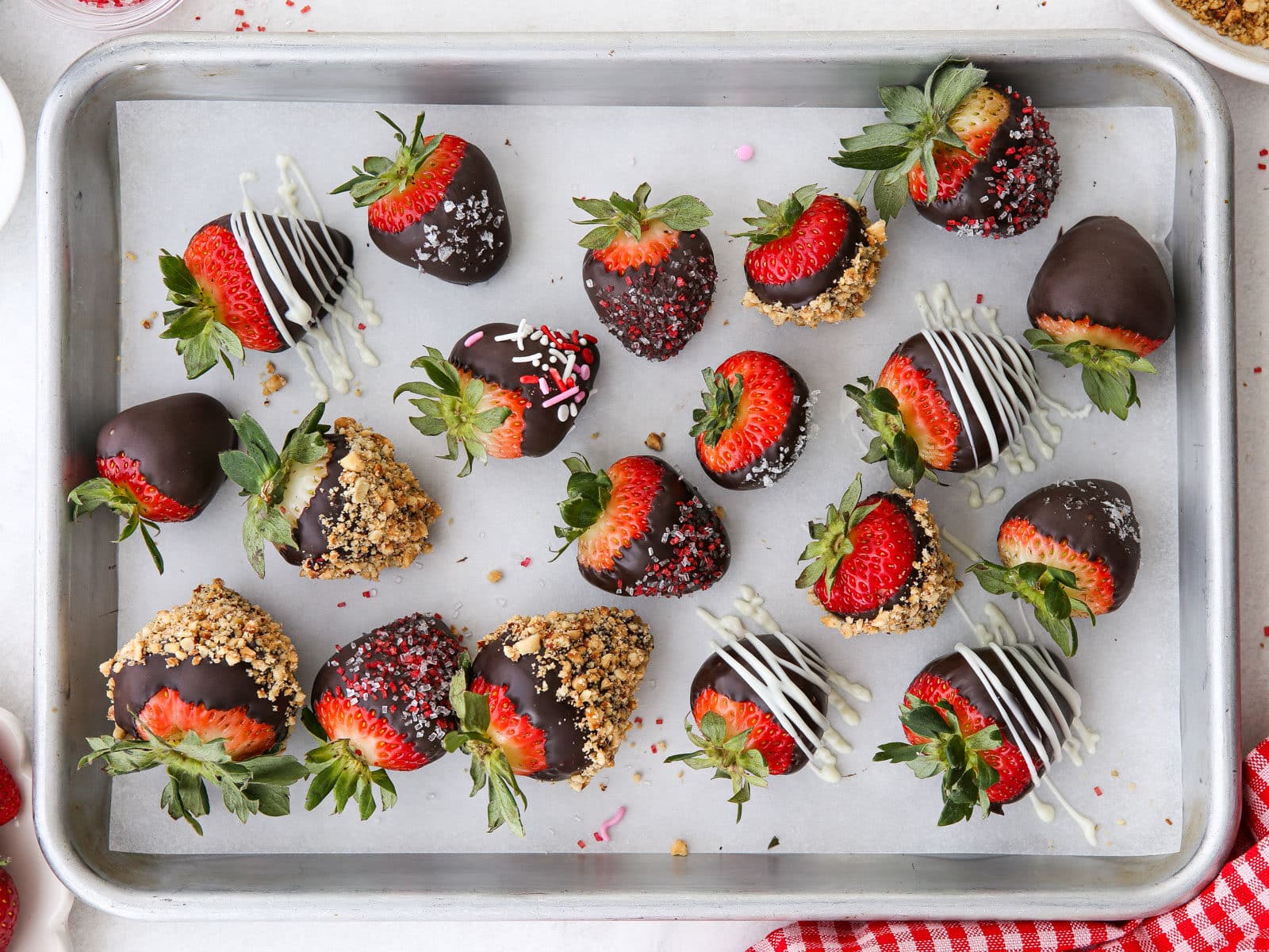 decorated chocolate covered strawberries on a sheet pan