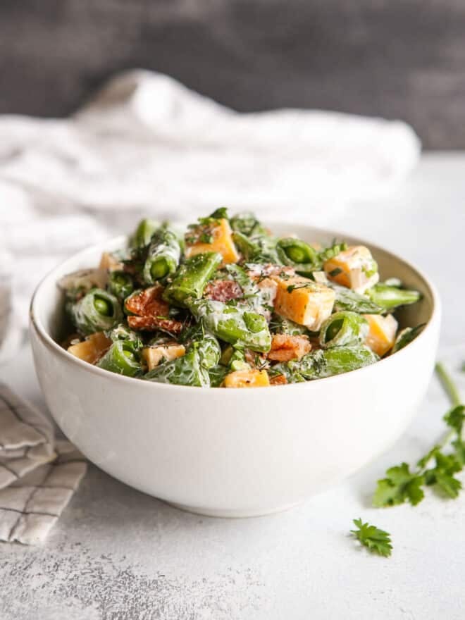 creamy sugar snap pea salad with bacon and cheddar in a bowl