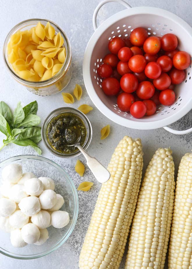 All of the ingredients for fresh corn, tomatoes, pesto and mozzarella salad