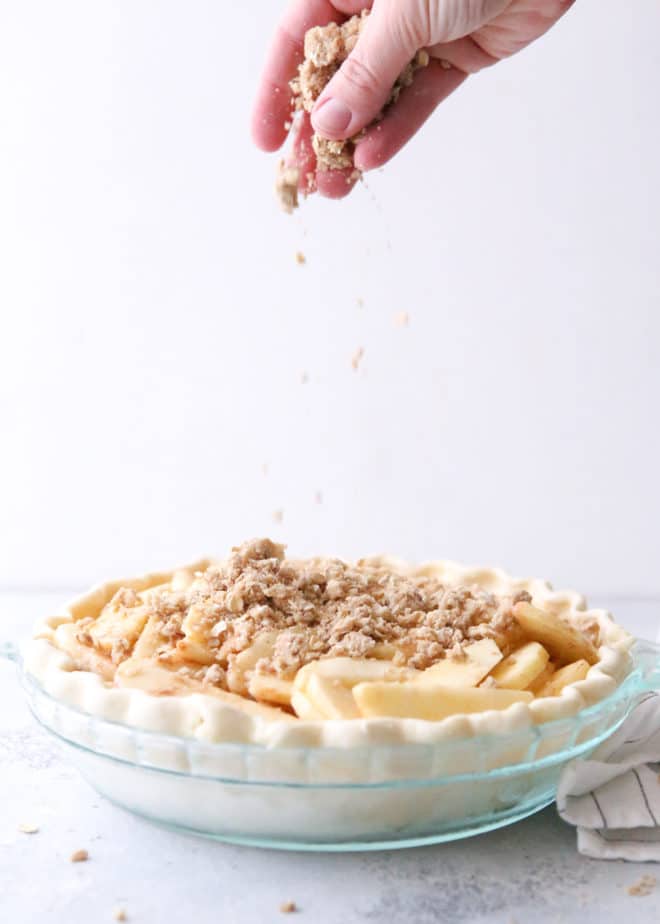 Adding the crumb topping to dutch apple pie