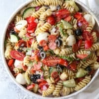 This quick and flavorful Italian pasta salad is filled with pepperoni, fresh mozzarella, bell peppers, tomatoes, cucumbers, olives and basil is perfect for potlucks and parties!