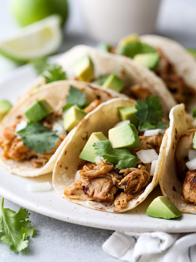 These easy Mexican street tacos filled with spiced shredded chicken, chopped onions, avocado, and cilantro are sure to become a favorite with everyone!