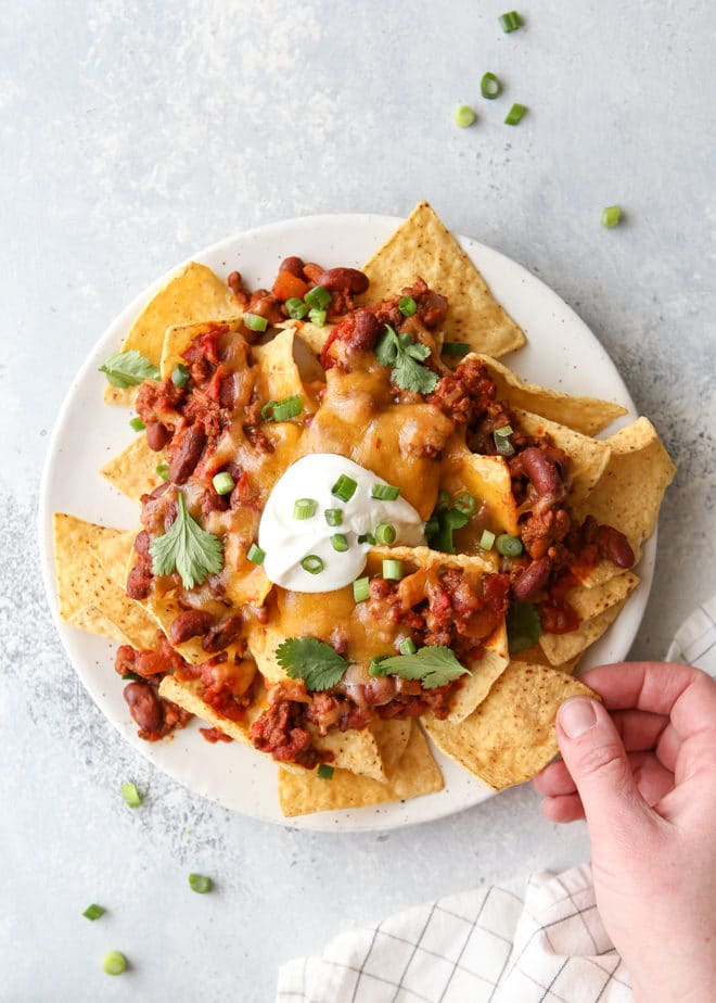 Topped with quick and easy homemade chili, plenty of cheddar cheese and sour cream, these nachos are sure to be a big hit!