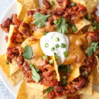 Topped with quick and easy homemade chili, plenty of cheddar cheese and sour cream, these nachos are sure to be a big hit!