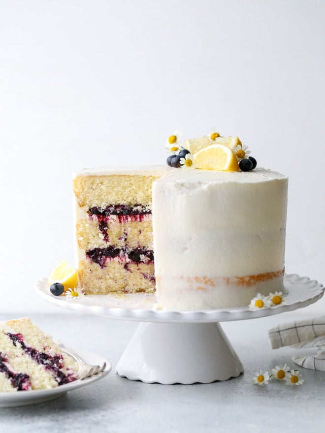 This light and tender lemon blueberry cake is filled with fresh blueberry preserves and frosted with silky lemon buttercream.