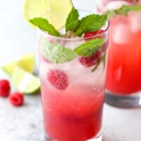 This refreshing mojito cocktail made with rum, mint, lime, and fresh raspberries is perfect for summer sipping!