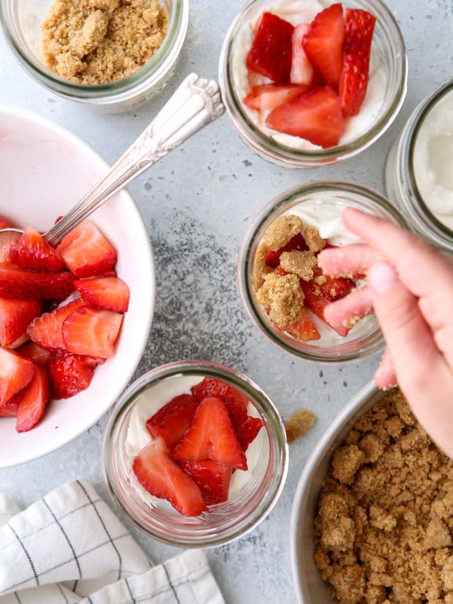Layers of fresh strawberries, yogurt whipped cream, and graham cracker crumble make up these adorable and irresistible parfaits.