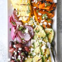 This grilled vegetable antipasto platter of zucchini, summer squash, red onion, bell peppers caramelized on the grill and served with kalamata olives, goat cheese and basil dressing is exactly what your next summer dinner party needs!