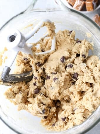 chocolate chip cookie dough in a bowl and wrapped caramels