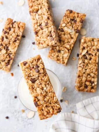 Homemade chewy chocolate chip granola bars with a chewy chocolate chip granola bar on top of a glass of milk