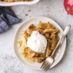 close up of classic apple crisp on plates with ice cream