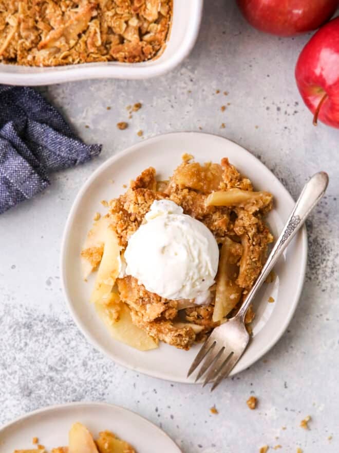 close up of classic apple crisp on plates with ice cream