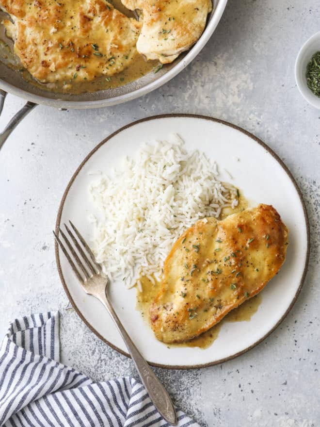 easy skillet chicken with herb butter sauce on a plate with rice