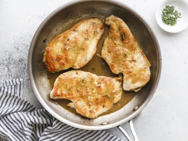 chicken with herb butter sauce in a skillet