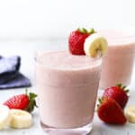 strawberry banana smoothie in cup with fruit