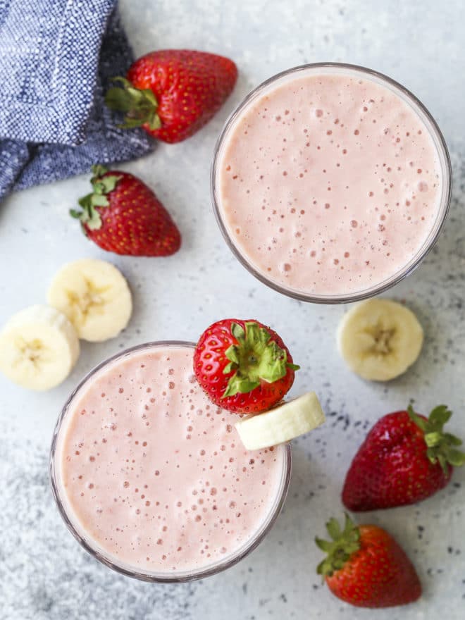 strawberry banana smoothie in cup with fruit from overhead