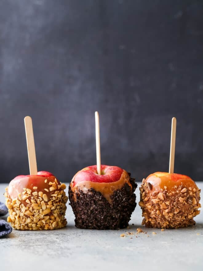 Three caramel apples with different toppings