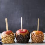 caramel apples with crushed oreos, nuts, and crushed candy bars