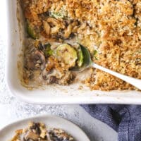 scooping brussels sprout and mushroom casserole out of baking dish