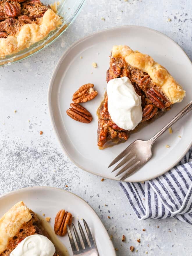 pecan pie slices on plates with whipped cream