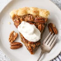 pecan pie piece with whipped cream on top