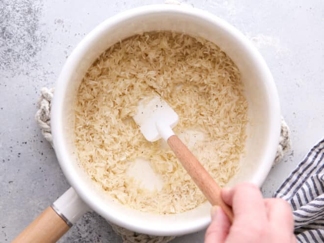 stirring rice with olive oil, salt and pepper