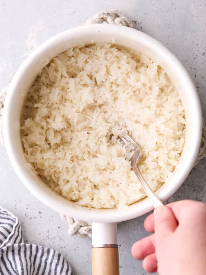 fluffing steamed rice in a pot