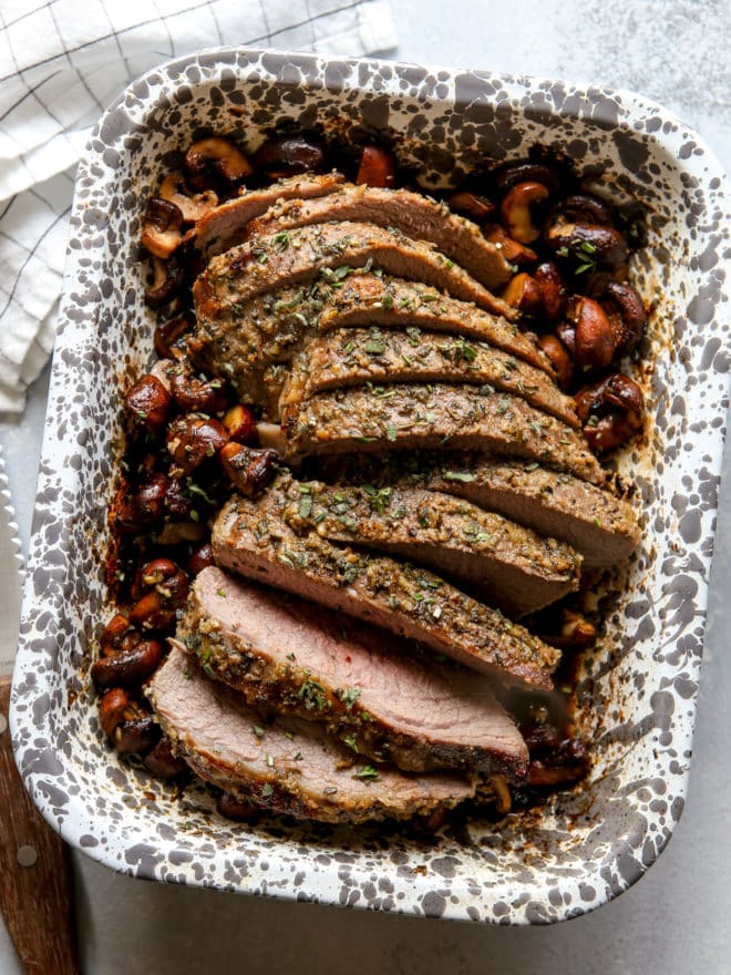 garlic and herb tri-tip roast with mushrooms sliced in baking dish