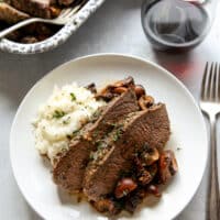 garlic and herb tri-tip roast with mushrooms on a plate