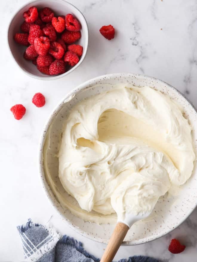 white chocolate buttercream frosting and a bowl of raspberries