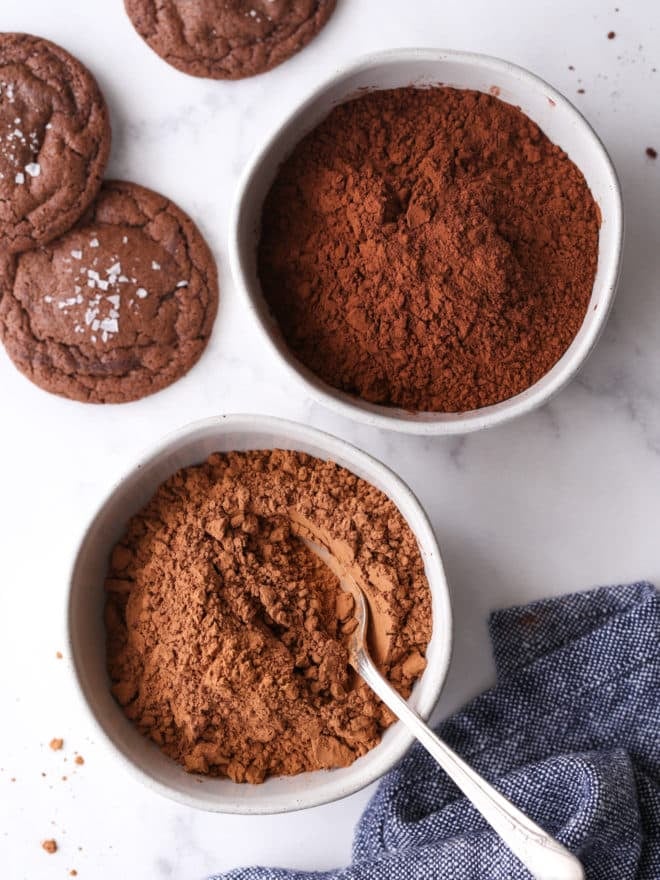 unsweetened cocoa powder and dutch process cocoa powder in bowls with cookies on the side