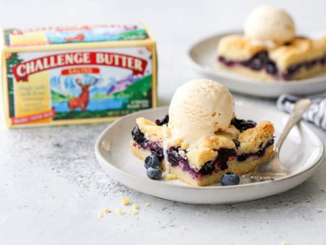 blueberry pie bars with ice cream and Challenge Butter box in background