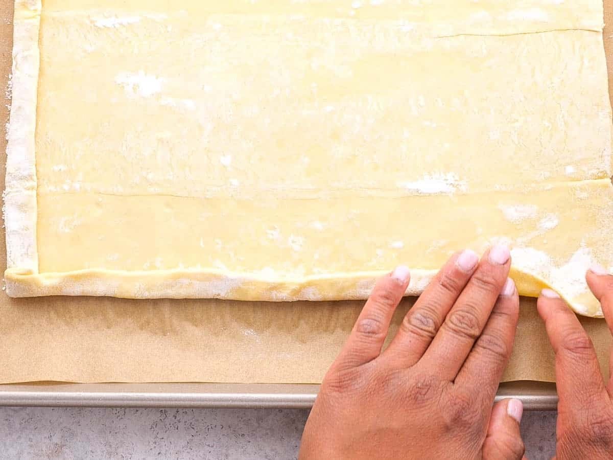 folding puff pastry edges over to form the edges of the tart