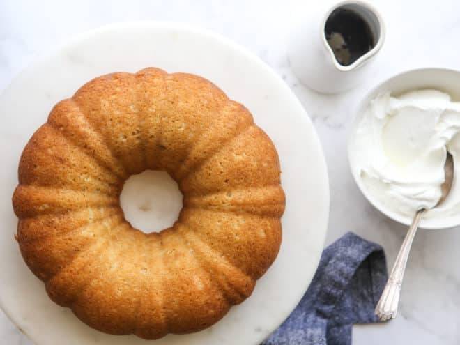 maple bundt cake with bowl of whipped cream and maple syrup