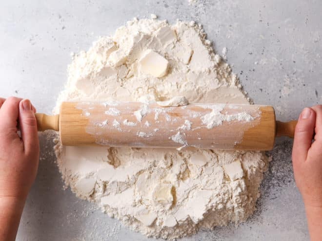 rolling butter into dry ingredients with rolling pin