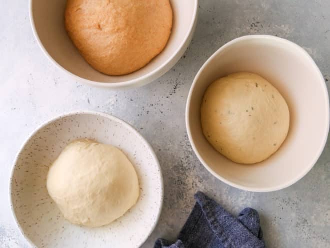 three risen doughs in bowls
