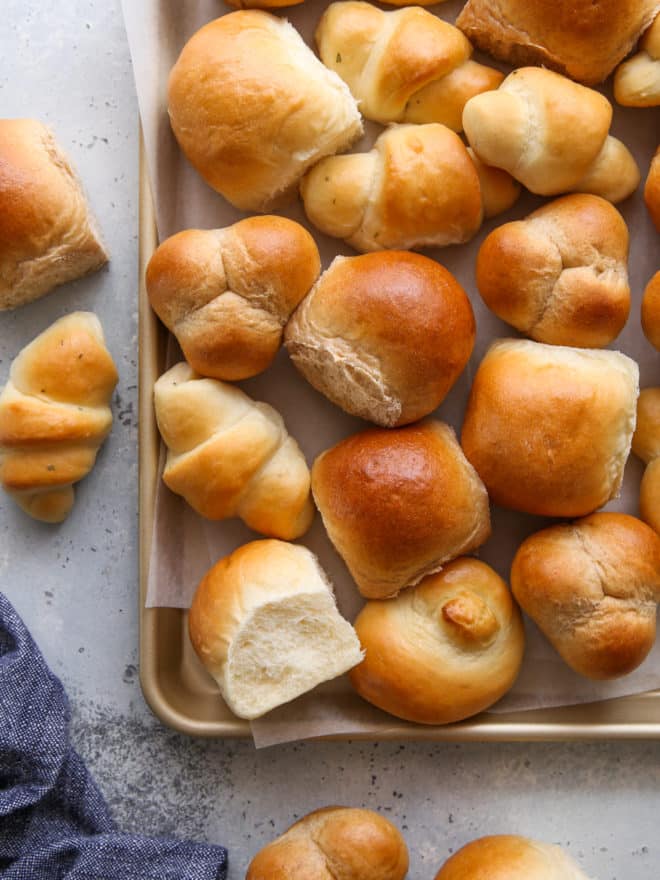 closeup of a sheet pan filled with different shapes and flavors of dinner rolls