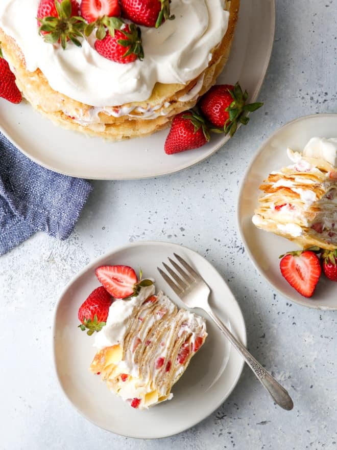 slices of strawberries and cream crepe cake on plates