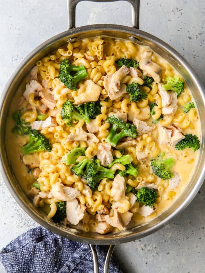 chicken broccoli macaroni and cheese in a skillet with towel