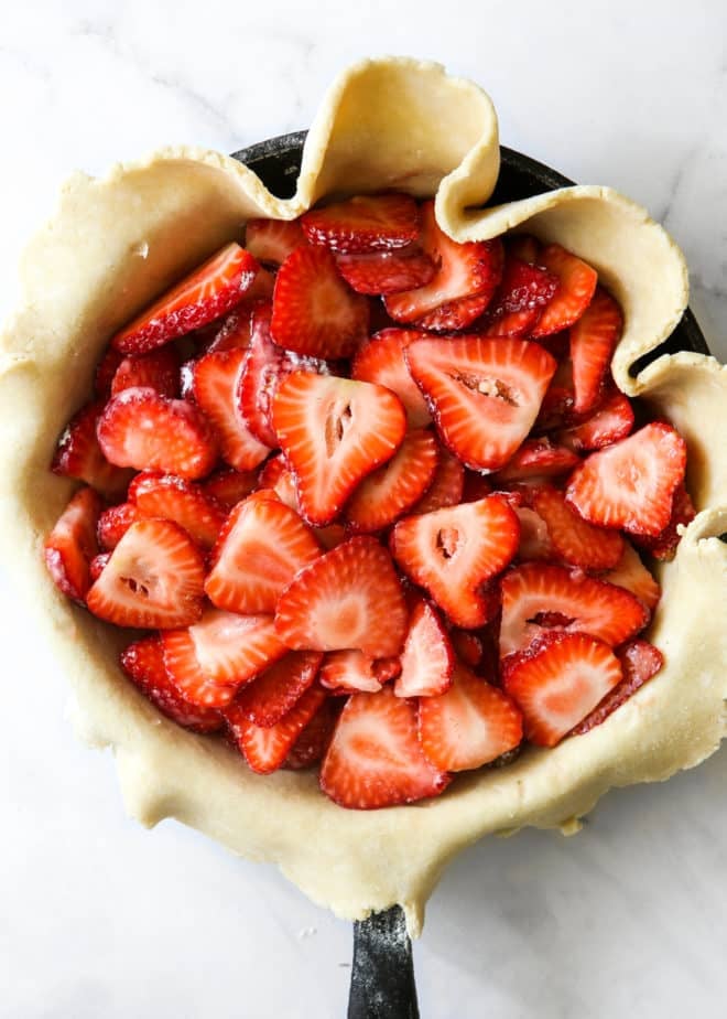 sliced strawberries in pie crust inside skillet