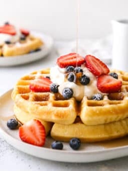 stack of buttermilk waffles with drizzle of syrup