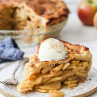 slice of mile high apple pie with ice cream on a plate
