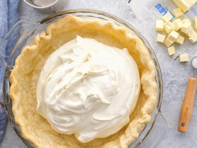full blind baked pie crust being filled with cream filling