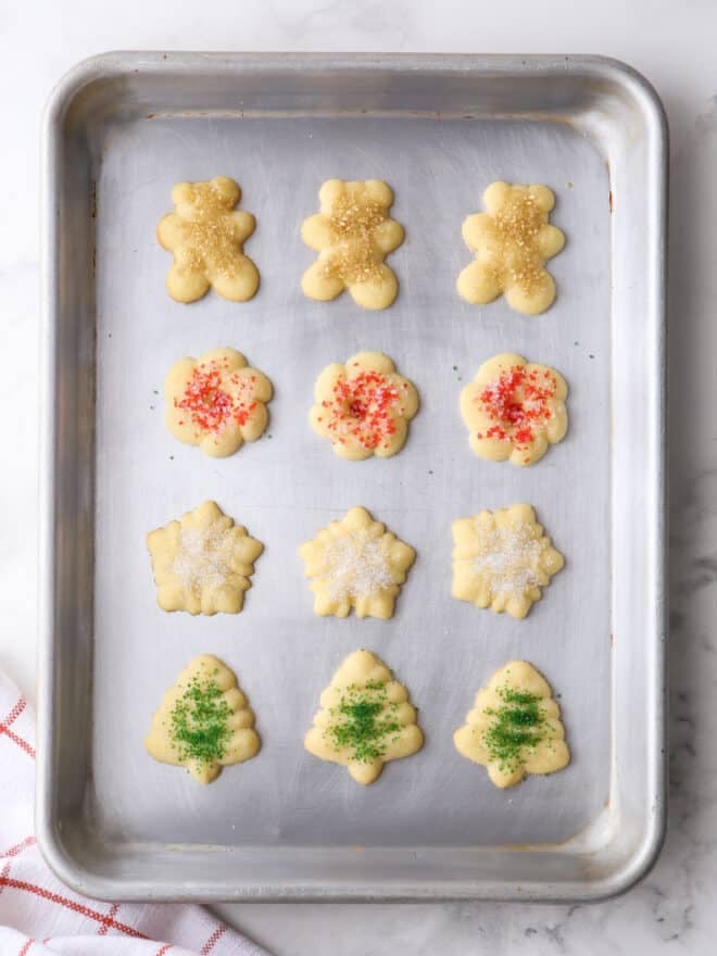 baked spritz cookies in different shapes with sprinkles