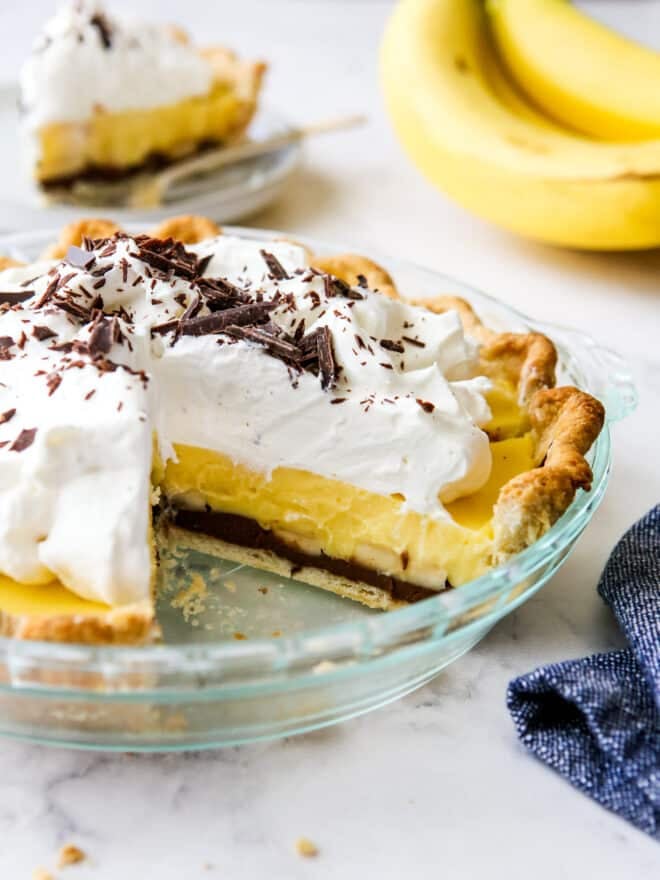 chocolate banana cream pie with slice taken out of it so you can see all the layers