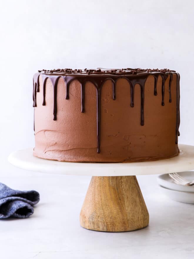 chocolate fudge layer cake on a cake stand