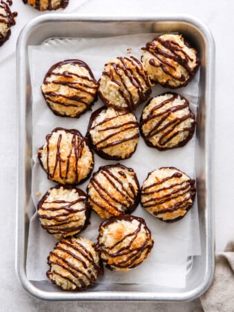coconut macaroons drizzled with chocolate on a sheet pan