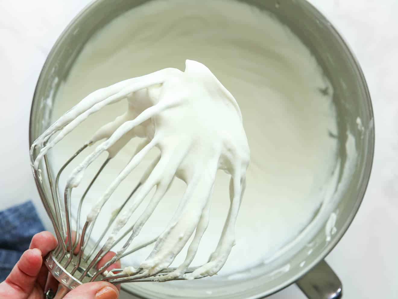 whipped cream filling in bowl with wire whisk