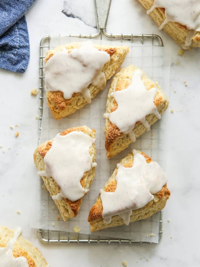 vanilla bean scones with frosting on a wire rack